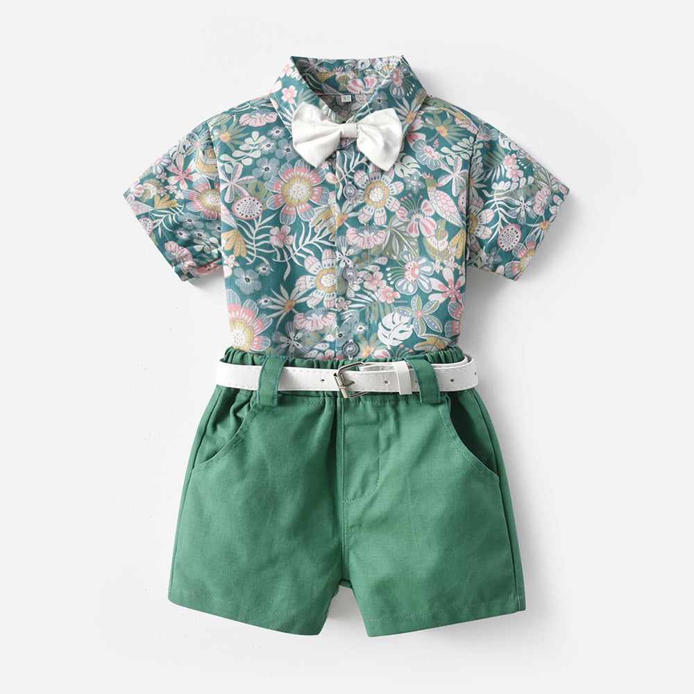 Children's clothing set with floral print shirt, green shorts, and bow tie for beach-style vacations.