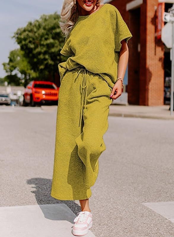 Women's casual two-piece set with solid color texture, featuring short-sleeved top and trousers in light green.