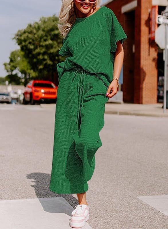 Solid color green two-piece women's outfit with short sleeves and trousers.