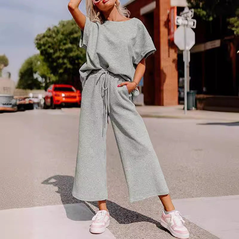 Women's solid color two-piece set with short sleeves and trousers in casual fashion.