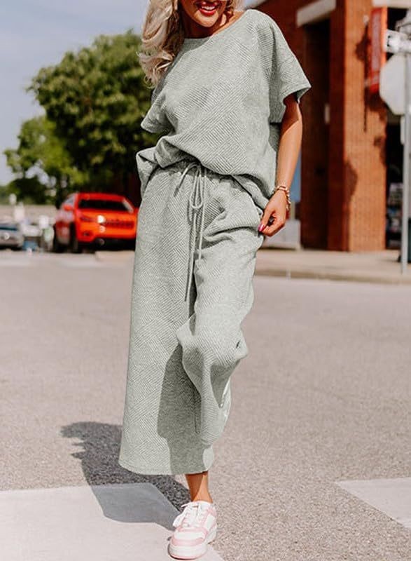 Solid color casual women's two-piece set with short sleeves and trousers in light green.