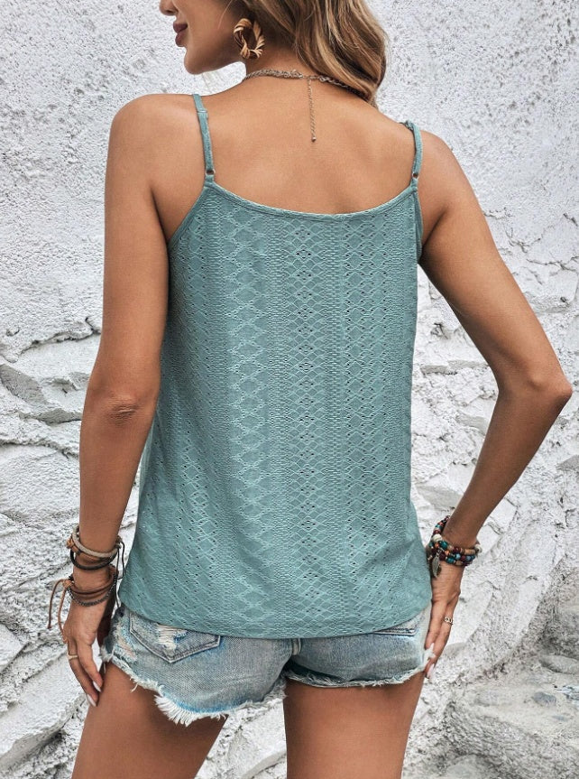 Women wearing a spaghetti strap cami with lace details, paired with denim shorts.