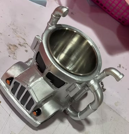 Handcrafted semi-truck shaped ceramic coffee mug on tabletop.