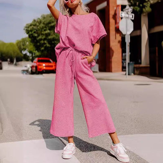 Solid color women's two-piece set with short sleeves and trousers in pink, casual fashion style.